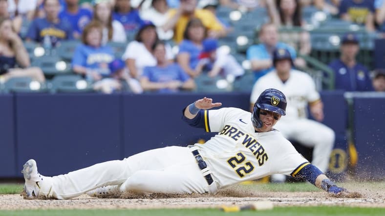 Jul 3, 2023; Milwaukee, Wisconsin, USA; Milwaukee Brewers left fielder Christian Yelich (22) slides into home plate to score a run during the eighth inning against the Chicago Cubs at American Family Field. Mandatory Credit: Jeff Hanisch-USA TODAY Sports