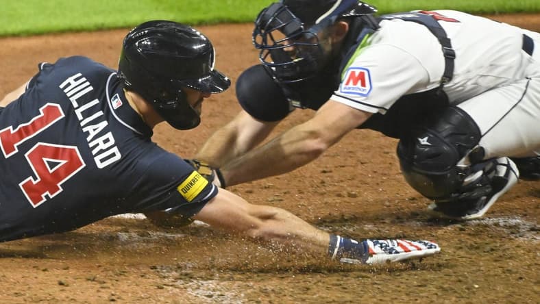 Jul 4, 2023; Cleveland, Ohio, USA; Cleveland Guardians catcher David Fry (12) tags out Atlanta Braves center fielder Sam Hilliard (14) in the tenth inning at Progressive Field. Mandatory Credit: David Richard-USA TODAY Sports