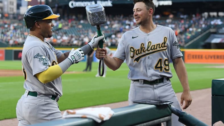 Jul 5, 2023; Detroit, Michigan, USA; Oakland Athletics first baseman Ryan Noda (49) (right) hands Thor's hammer to Oakland Athletics designated hitter Jordan Diaz (13) after Diaz hit a home run against the Detroit Tigers in the eighth inning at Comerica Park. Mandatory Credit: Lon Horwedel-USA TODAY Sports