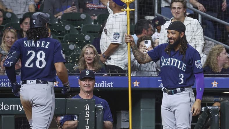 Jul 6, 2023; Houston, Texas, USA; Seattle Mariners shortstop J.P. Crawford (3) presents a trident to third baseman Eugenio Suarez (28) after Suarez hits a home run during the ninth inning against the Houston Astros at Minute Maid Park. Mandatory Credit: Troy Taormina-USA TODAY Sports