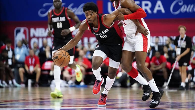 Jul 7, 2023; Las Vegas, NV, USA; Portland Trail Blazers guard Scoot Henderson (00) dribbles the ball against Houston Rockets guard/forward Nate Hinton (62) during the first half at Thomas & Mack Center. Mandatory Credit: Lucas Peltier-USA TODAY Sports
