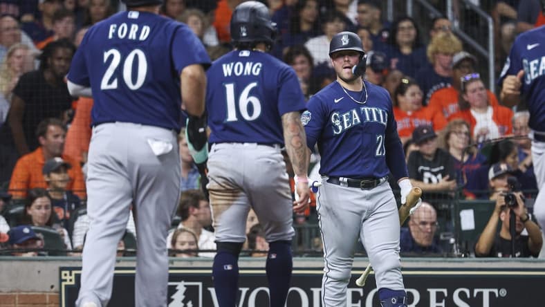 Jul 7, 2023; Houston, Texas, USA; Seattle Mariners designated hitter Mike Ford (20) and second baseman Kolten Wong (16) celebrate after scoring during the fourth inning against the Houston Astros at Minute Maid Park. Mandatory Credit: Troy Taormina-USA TODAY Sports