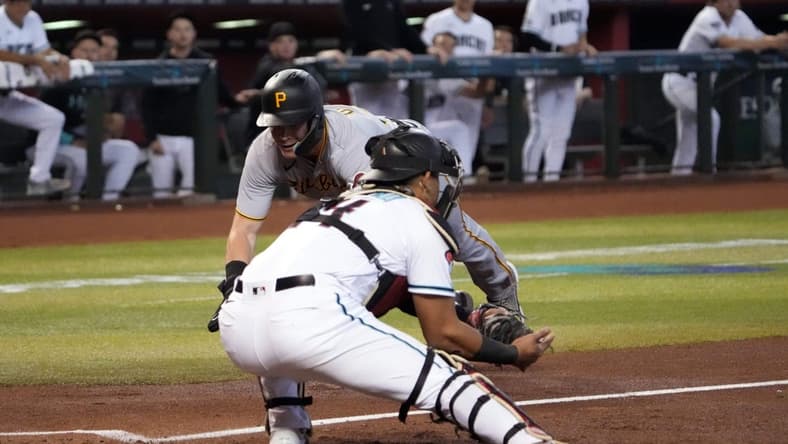 Jul 8, 2023; Phoenix, Arizona, USA; Pittsburgh Pirates catcher Henry Davis (32) is unable to beat a throw to Arizona Diamondbacks catcher Gabriel Moreno (14) and is tagged out at home during the third inning at Chase Field. Mandatory Credit: Joe Camporeale-USA TODAY Sports