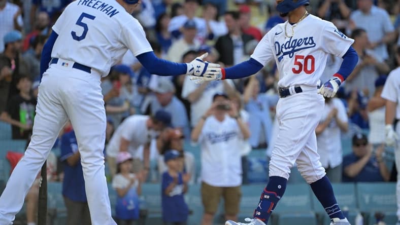 Jul 8, 2023; Los Angeles, California, USA; Los Angeles Dodgers first baseman Freddie Freeman (5) congratulates right fielder Mookie Betts (50) rounds third after hitting a lead off solo home run in the first inning at Dodger Stadium. Mandatory Credit: Jayne Kamin-Oncea-USA TODAY Sports