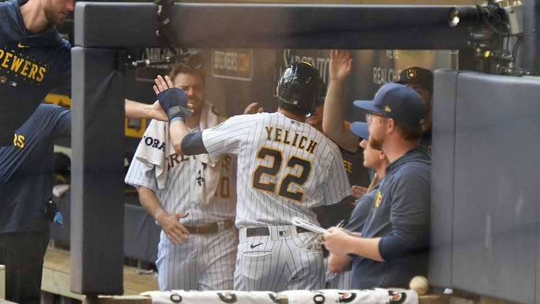 Jul 9, 2023; Milwaukee, Wisconsin, USA; Milwaukee Brewers left fielder Christian Yelich (22) celebrates in the dugout after scoring a run against the Cincinnati Reds in the first inning at American Family Field. Mandatory Credit: Michael McLoone-USA TODAY Sports