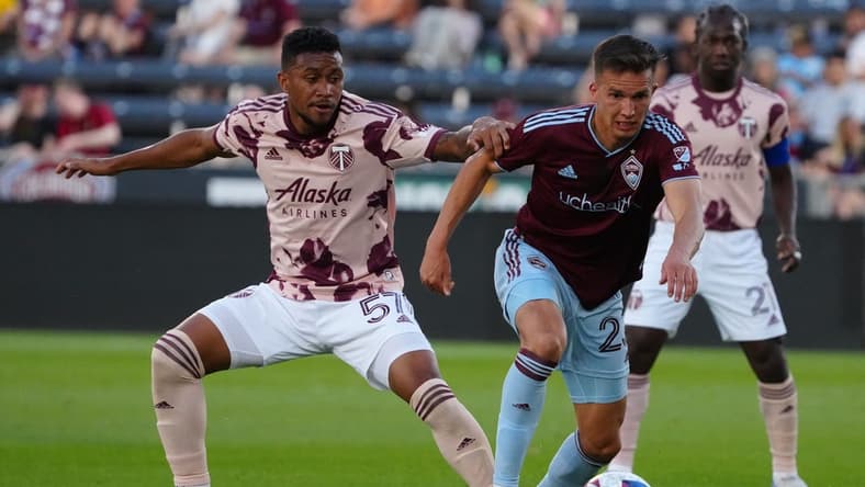 Jul 12, 2023; Commerce City, Colorado, USA; Colorado Rapids midfielder Cole Bassett (23) and Portland Timbers midfielder Victor Griffith (57) battle for the ball during the second half at Dick's Sporting Goods Park. Mandatory Credit: Ron Chenoy-USA TODAY Sports