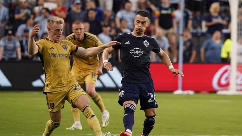 Jul 12, 2023; Kansas City, Kansas, USA; Real Salt Lake defender Jasper Loffelsend (28) fights for the ball against Sporting Kansas City midfielder Erik Thommy (26) during the first half at Children's Mercy Park. Mandatory Credit: Denny Medley-USA TODAY Sports