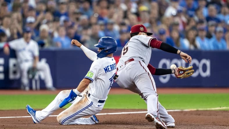 Jul 15, 2023; Toronto, Ontario, CAN; Toronto Blue Jays second baseman Whit Merrifield (15) slides into third base by Arizona Diamondbacks third baseman Emmanuel Rivera (15) during the second inning at Rogers Centre. Mandatory Credit: Kevin Sousa-USA TODAY Sports