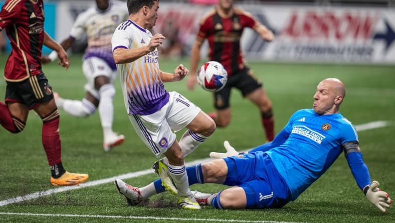 Jul 15, 2023; Atlanta, Georgia, USA; Atlanta United goalkeeper Brad Guzan (1) stops a scoring chance by Orlando City midfielder Mauricio Pereyra (10) during the first half at Mercedes-Benz Stadium. Mandatory Credit: Dale Zanine-USA TODAY Sports