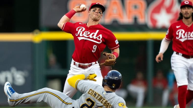 Cincinnati Reds shortstop Matt McLain (9) turns a double play as Milwaukee Brewers catcher William Contreras (24) slides into second in the first inning of the MLB baseball game between the Cincinnati Reds and the Milwaukee Brewers at Great American Ball Park in Cincinnati on Saturday, July 15, 2023.