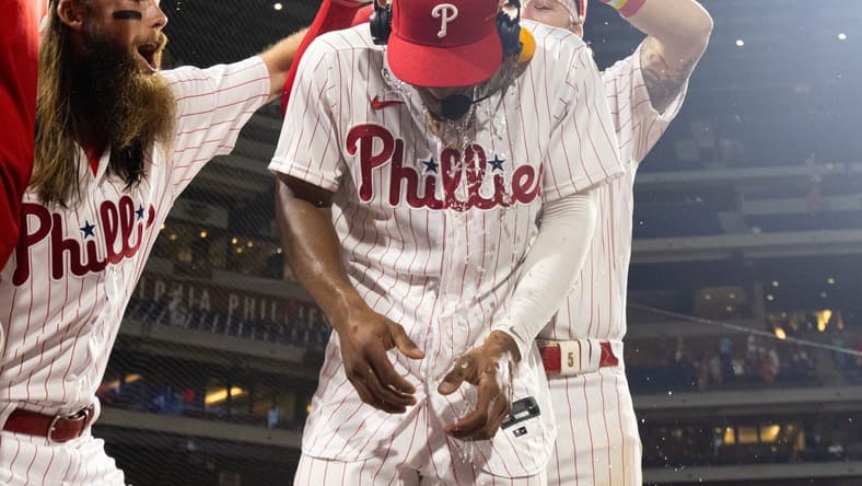 Jul 15, 2023; Philadelphia, Pennsylvania, USA; Philadelphia Phillies outfielder Johan Rojas (18) has water dumped on him by center fielder Brandon Marsh (16) and second baseman Bryson Stott (5) after a victory against the San Diego Padres at Citizens Bank Park. Mandatory Credit: Bill Streicher-USA TODAY Sports