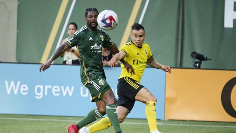 Jul 15, 2023; Portland, Oregon, USA; Columbus Crew midfielder Lucas Zelarrayan (10) crosses the ball during the first half against Portland Timbers forward Dairon Asprilla (27) at Providence Park. Mandatory Credit: Troy Wayrynen-USA TODAY Sports