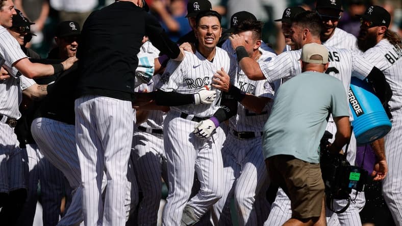 Jul 16, 2023; Denver, Colorado, USA; Colorado Rockies second baseman Alan Trejo (13) celebrates with teammates on a walk-off solo home run in the eleventh inning against the New York Yankees at Coors Field. Mandatory Credit: Isaiah J. Downing-USA TODAY Sports