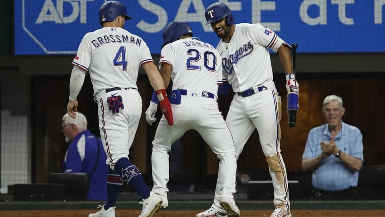Jul 17, 2023; Arlington, Texas, USA; Texas Rangers left fielder Ezequiel Duran (20) is congratulated by designated hitter Robbie Grossman (4) and second baseman Marcus Semien (2) after hitting a two-run home run in the sixth inning against the Tampa Bay Rays at Globe Life Field. Mandatory Credit: Tim Heitman-USA TODAY Sports