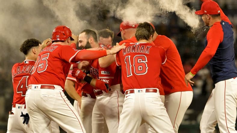 Jul 17, 2023; Anaheim, California, USA; Los Angeles Angels second baseman Michael Stefanic (38) is mobbed after a pinch hit RBI single in the 10th inning to defeat the New York Yankees at Angel Stadium. Mandatory Credit: Jayne Kamin-Oncea-USA TODAY Sports