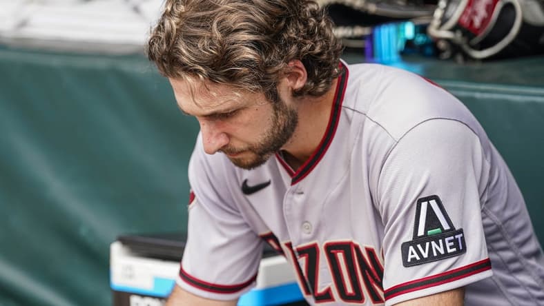 Jul 20, 2023; Cumberland, Georgia, USA; Arizona Diamondbacks starting pitcher Zac Gallen (23) studies a tablet in the dugout against the Atlanta Braves during the second inning at Truist Park. Mandatory Credit: Dale Zanine-USA TODAY Sports