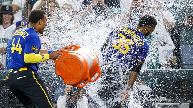 Jul 21, 2023; Seattle, Washington, USA; Seattle Mariners designated hitter Teoscar Hernandez (35) receives a water-bucket dunking from center fielder Julio Rodriguez (44) after hitting a walk-off RBI-single against the Toronto Blue Jays during the ninth inning at T-Mobile Park. Mandatory Credit: Joe Nicholson-USA TODAY Sports