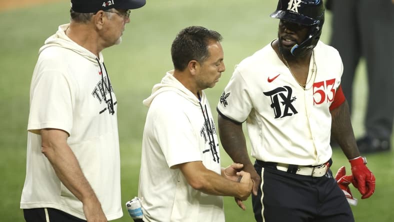 Jul 22, 2023; Arlington, Texas, USA; Texas Rangers right fielder Adolis Garcia (53) is attended to by head trainer Matt Lucero and manager Bruce Bochy (left) after being hit by a pitch in the fourth inning against the Los Angeles Dodgers at Globe Life Field. Mandatory Credit: Tim Heitman-USA TODAY Sports