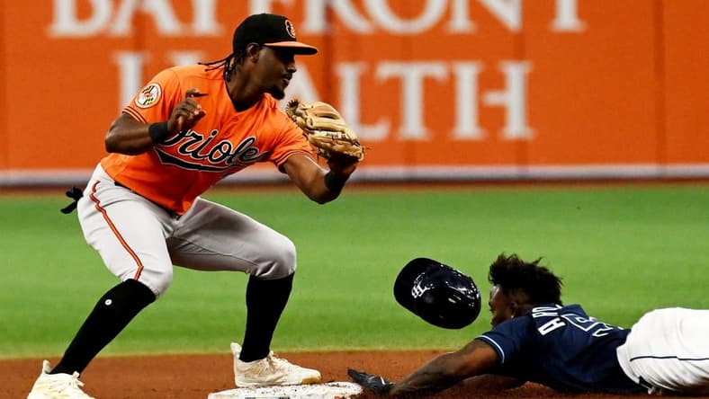Jul 22, 2023; St. Petersburg, Florida, USA; Tampa Bay Rays left fielder Randy Arozarena (56) lies as Baltimore Orioles short stop Jorge Mateo (3) attempts to place the tag in the eighth inning at Tropicana Field. Mandatory Credit: Jonathan Dyer-USA TODAY Sports