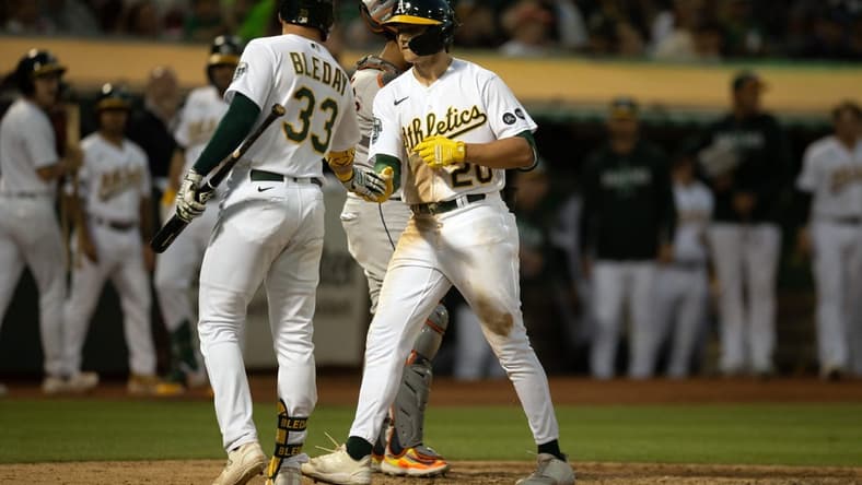 Jul 22, 2023; Oakland, California, USA; Oakland Athletics second baseman Zack Gelof (20) gets a congratulatory handshake from JJ Bleday (33) after hitting his first career home run during the seventh inning against the Houston Astros at Oakland-Alameda County Coliseum. Mandatory Credit: D. Ross Cameron-USA TODAY Sports