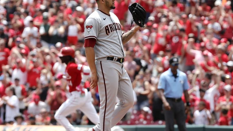 Jul 23, 2023; Cincinnati, Ohio, USA; Arizona Diamondbacks relief pitcher Jose Ruiz (right) waits for a new ball after Cincinnati Reds third baseman Elly De La Cruz (left) runs the bases after hitting a solo home during the first inning at Great American Ball Park. Mandatory Credit: David Kohl-USA TODAY Sports