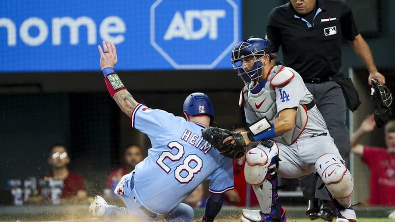 Jul 23, 2023; Arlington, Texas, USA;  Texas Rangers catcher Jonah Heim (28) scores ahead of the tag by Los Angeles Dodgers catcher Austin Barnes (15) during the fourth inning at Globe Life Field. Mandatory Credit: Kevin Jairaj-USA TODAY Sports
