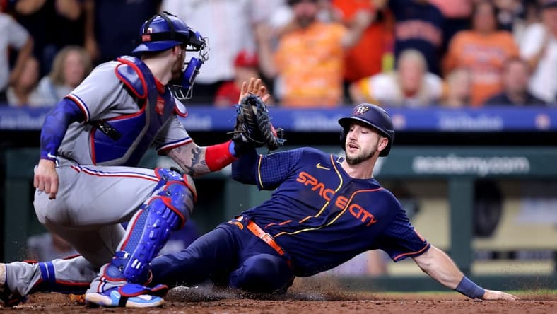Jul 24, 2023; Houston, Texas, USA; Houston Astros right fielder Kyle Tucker (30) slides into home plate to score the game winning run while beating the tag of Texas Rangers catcher Jonah Heim (28) during the ninth inning at Minute Maid Park. Mandatory Credit: Erik Williams-USA TODAY Sports