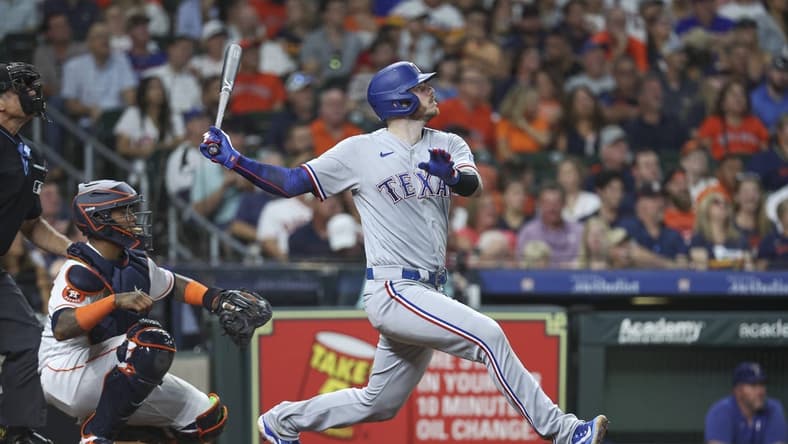 Jul 25, 2023; Houston, Texas, USA; Texas Rangers catcher Jonah Heim (28) hits a single during the fifth inning against the Houston Astros at Minute Maid Park. Mandatory Credit: Troy Taormina-USA TODAY Sports