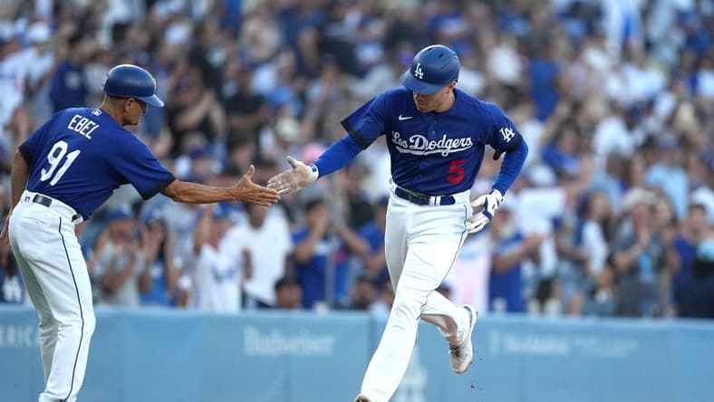 Jul 25, 2023; Los Angeles, California, USA; Los Angeles Dodgers first baseman Freddie Freeman (5) is congratulated by third base coach Dino Ebel (91) after hitting a solo home run in the first inning against the Toronto Blue Jays at Dodger Stadium. Mandatory Credit: Kirby Lee-USA TODAY Sports