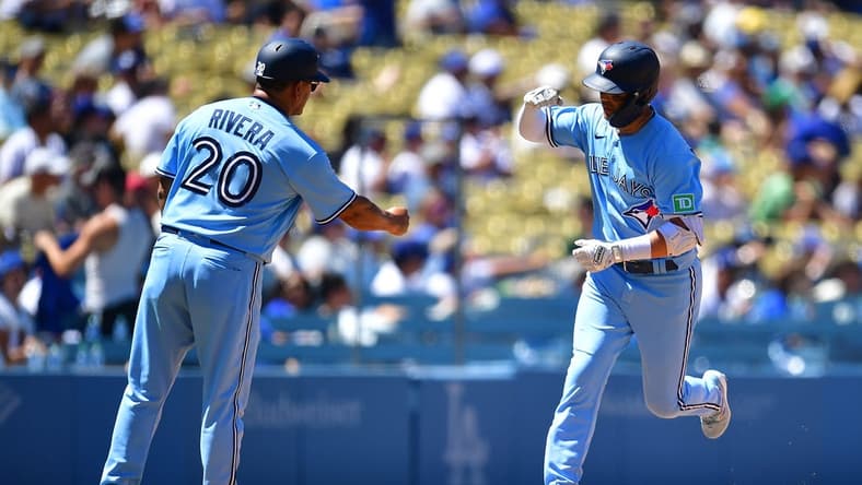 Jul 26, 2023; Los Angeles, California, USA; Toronto Blue Jays left fielder Whit Merrifield (15) is greeted by third base coach Luis Rivera (20) after hitting a three run home run against the Los Angeles Dodgers during the fifth inning at Dodger Stadium. Mandatory Credit: Gary A. Vasquez-USA TODAY Sports