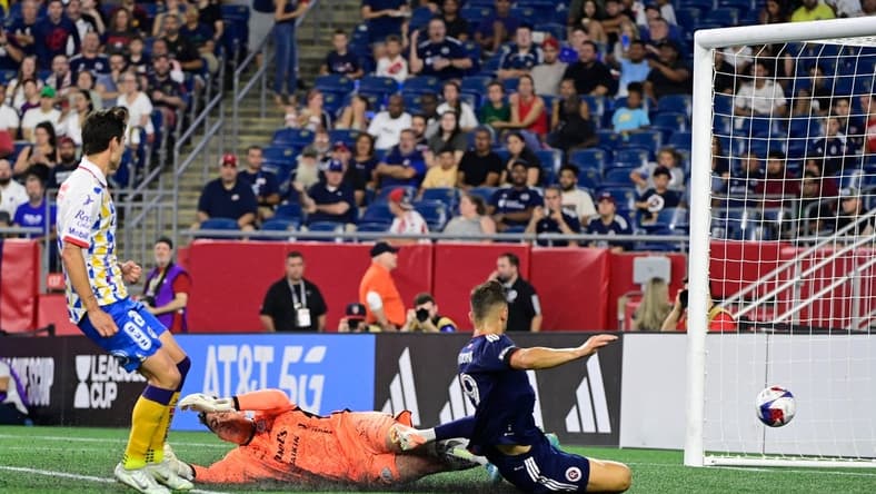 Jul 26, 2023; Foxborough, MA, USA; New England Revolution forward Giacomo Vrioni (9) scores a goal on Club Atletico de San Luis goalkeeper Andres Sanchez (1)  during the second half at Gillette Stadium. Mandatory Credit: Eric Canha-USA TODAY Sports
