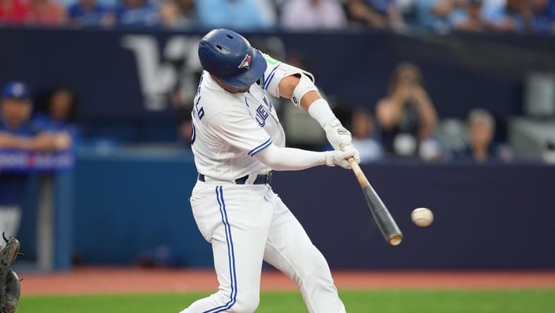 Jul 28, 2023; Toronto, Ontario, CAN; Toronto Blue Jays second baseman Whit Merrifield (15) hits a single against the Los Angeles Angels during the third inning at Rogers Centre. Mandatory Credit: Nick Turchiaro-USA TODAY Sports