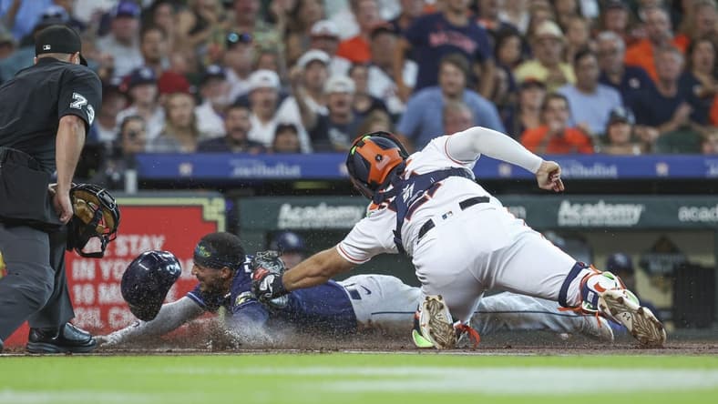 Jul 29, 2023; Houston, Texas, USA; Tampa Bay Rays shortstop Wander Franco (5) is out on a play at home plate as Houston Astros catcher Yainer Diaz (21) applies a tag during the first inning at Minute Maid Park. Mandatory Credit: Troy Taormina-USA TODAY Sports