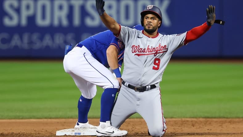 Jul 29, 2023; New York City, New York, USA; Washington Nationals third baseman Jeimer Candelario (9) reacts after an RBI double during the second inning as New York Mets shortstop Danny Mendick (15) holds the tag at Citi Field. Mandatory Credit: Vincent Carchietta-USA TODAY Sports