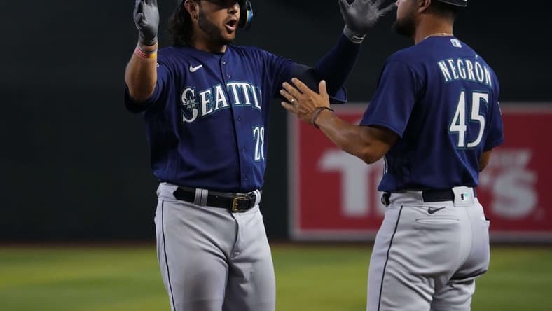 Jul 30, 2023; Phoenix, Arizona, USA; Seattle Mariners third baseman Eugenio Suarez (28) celebrates with Seattle Mariners first base coach Kristopher Negr n (45) after hitting an RBI single against the Arizona Diamondbacks during the ninth inning at Chase Field. Mandatory Credit: Joe Camporeale-USA TODAY Sports