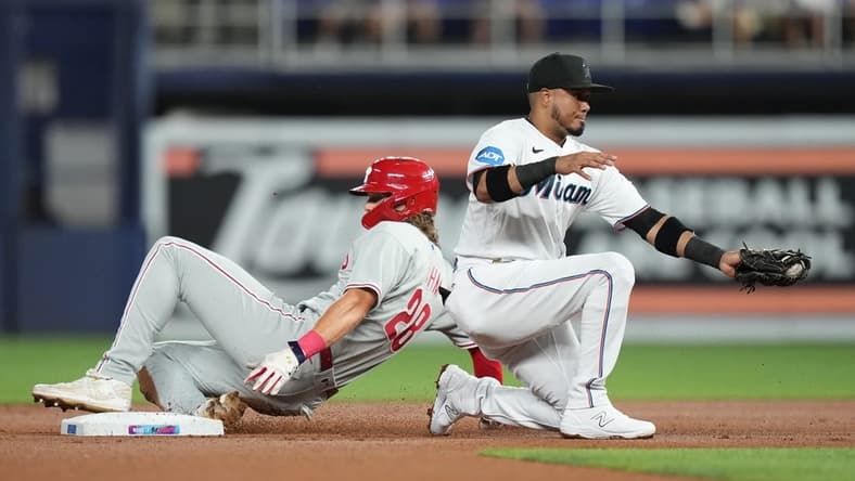 Jul 31, 2023; Miami, Florida, USA; Philadelphia Phillies first baseman Alec Bohm (28) steals second base as Miami Marlins second baseman Luis Arraez (3) gathers the ball in the first inning at loanDepot Park. Mandatory Credit: Jim Rassol-USA TODAY Sports