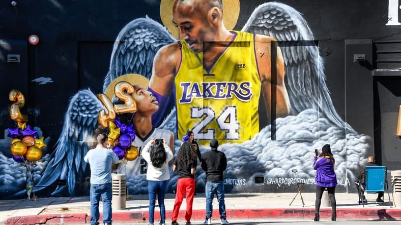 Jan 26, 2021; Los Angeles, California, USA; Fans gather at a mural of Kobe Bryant and his daughter Gianna painted on the wall of Hardcore Fitness Bootcamp gym in downtown Los Angeles. Bryant and his daughter and seven other persons died in a helicopter crash in Calabasas, Calif. on Jan. 26, 2020. Mandatory Credit: Robert Hanashiro-USA TODAY Sports
