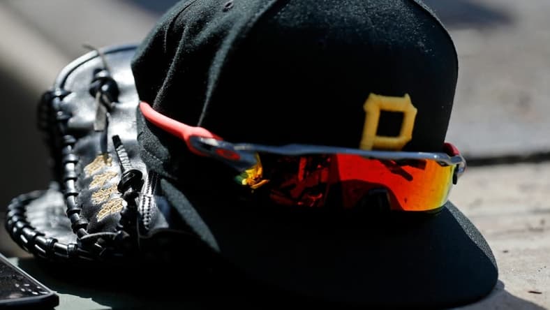Apr 23, 2022; Chicago, Illinois, USA; A detail view of the glove, hat, and sunglasses of Pittsburgh Pirates first baseman Yoshi Tsutsugo (not pictured) during the eighth inning of their game against the Chicago Cubs at Wrigley Field. Mandatory Credit: Jon Durr-USA TODAY Sports