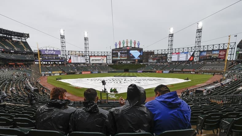 Jun 25, 2022; Chicago, Illinois, USA; Fans wait for a start of a baseball game between the Baltimore Orioles and the Chicago White Sox as tarp covers the infield during a rain delay at Guaranteed Rate Field. Mandatory Credit: Kamil Krzaczynski-USA TODAY Sports