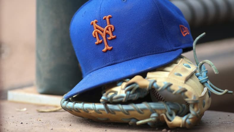 Jul 13, 2022; Atlanta, Georgia, USA; A detailed view of a New York Mets hat and glove in the dugout against the Atlanta Braves in the eighth inning at Truist Park. Mandatory Credit: Brett Davis-USA TODAY Sports