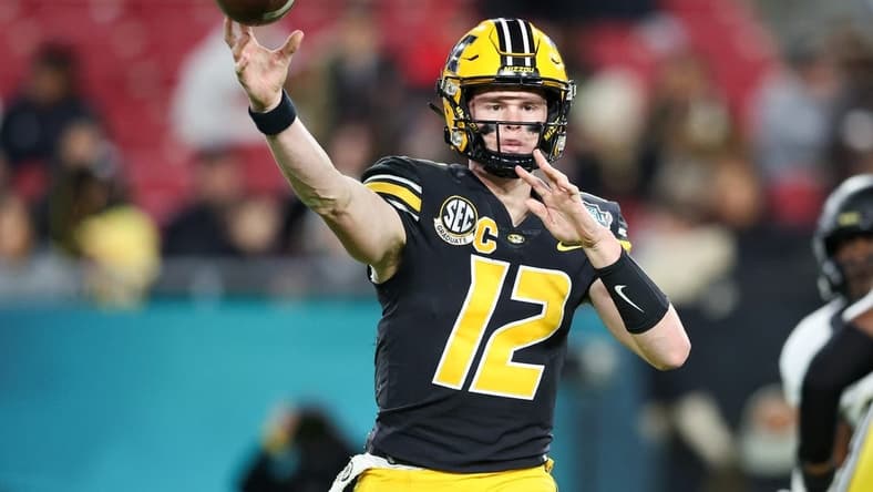 Dec 23, 2022; Tampa, Florida, USA; Missouri Tigers quarterback Brady Cook (12) throws a pass against the Wake Forest Demon Deacons during the first quarter in the 2022 Gasparilla Bowl at Raymond James Stadium. Mandatory Credit: Nathan Ray Seebeck-USA TODAY Sports