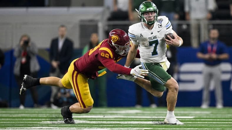 Jan 2, 2023; Arlington, Texas, USA; Tulane Green Wave quarterback Michael Pratt (7) and USC Trojans defensive lineman Nick Figueroa (99) in action during the game between the USC Trojans and the Tulane Green Wave in the 2023 Cotton Bowl at AT&T Stadium. Mandatory Credit: Jerome Miron-USA TODAY Sports