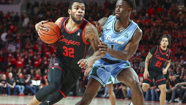 Feb 22, 2023; Houston, Texas, USA; Houston Cougars forward Reggie Chaney (32) drives with the ball as Tulane Green Wave guard Sion James (1) defends during the second half at Fertitta Center. Mandatory Credit: Troy Taormina-USA TODAY Sports