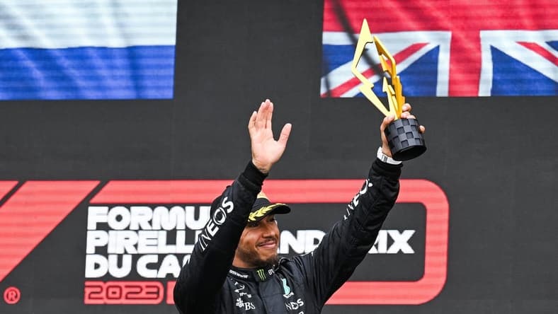 Jun 18, 2023; Montreal, Quebec, CAN; Mercedes driver Lewis Hamilton (GBR) salutes the crowd holding his third place trophy of the Canadian Grand Prix at Circuit Gilles Villeneuve. Mandatory Credit: David Kirouac-USA TODAY Sports