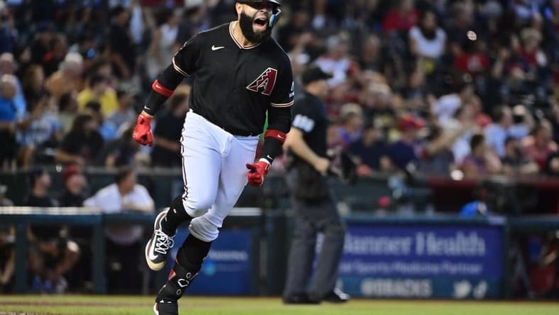 Jul 26, 2023; Phoenix, Arizona, USA;  Arizona Diamondbacks third baseman Emmanuel Rivera (15) hits a solo home run in the sixth inning against the St. Louis Cardinals at Chase Field. Mandatory Credit: Matt Kartozian-USA TODAY Sports
