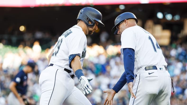 Jul 31, 2023; Seattle, Washington, USA; Seattle Mariners catcher Cal Raleigh (29) receives a greeting from third base coach Manny Acta (14) while running the bases following a solo-home run against the Boston Red Sox during the second inning at T-Mobile Park. Mandatory Credit: Joe Nicholson-USA TODAY Sports