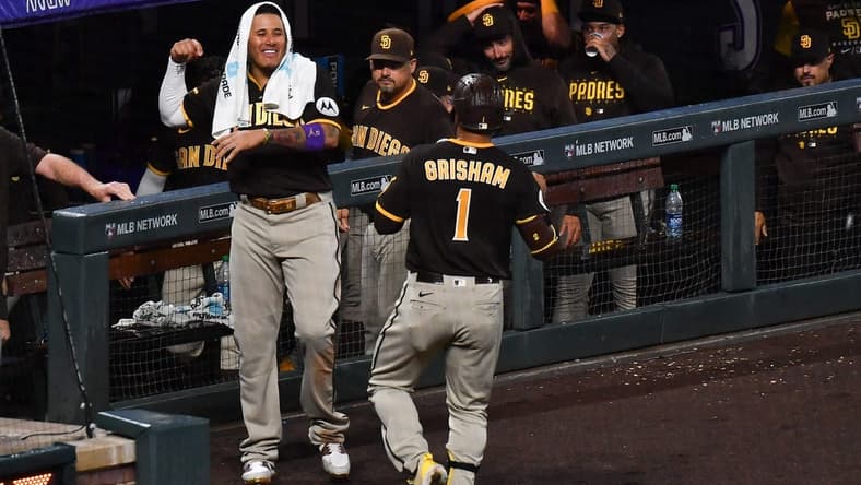 Jul 31, 2023; Denver, Colorado, USA; San Diego Padres third baseman Manny Machado (13) comes out of the dugout to greet center fielder Trent Grisham (1) after hitting a home run in the ninth inning to tie the game against the Colorado Rockies at Coors Field. Mandatory Credit: John Leyba-USA TODAY Sports