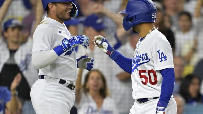 Aug 2, 2023; Los Angeles, California, USA; Los Angeles Dodgers shortstop Miguel Rojas (11) is greeted by right fielder Mookie Betts (50) after hitting a solo home run in the third inning against the Oakland Athletics at Dodger Stadium. Mandatory Credit: Jayne Kamin-Oncea-USA TODAY Sports