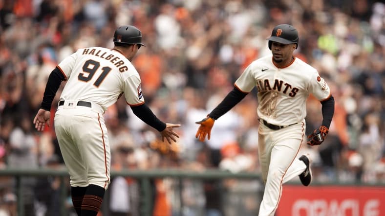 Aug 3, 2023; San Francisco, California, USA; San Francisco Giants first baseman LaMonte Wade Jr. (right) gets a congratulatory handshake from third base coach Mark Hallberg (91) after hitting a solo home run off Arizona Diamondbacks starting pitcher Brandon Pfaadt during the fourth inning at Oracle Park. Mandatory Credit: D. Ross Cameron-USA TODAY Sports