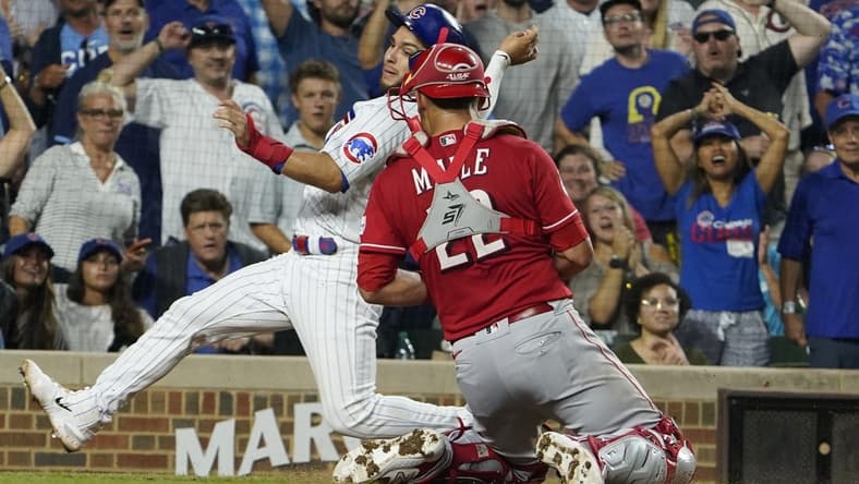 Aug 3, 2023; Chicago, Illinois, USA; Cincinnati Reds catcher Luke Maile (22) tags out Chicago Cubs third baseman Nick Madrigal (1) during the fourth inning at Wrigley Field. Mandatory Credit: David Banks-USA TODAY Sports